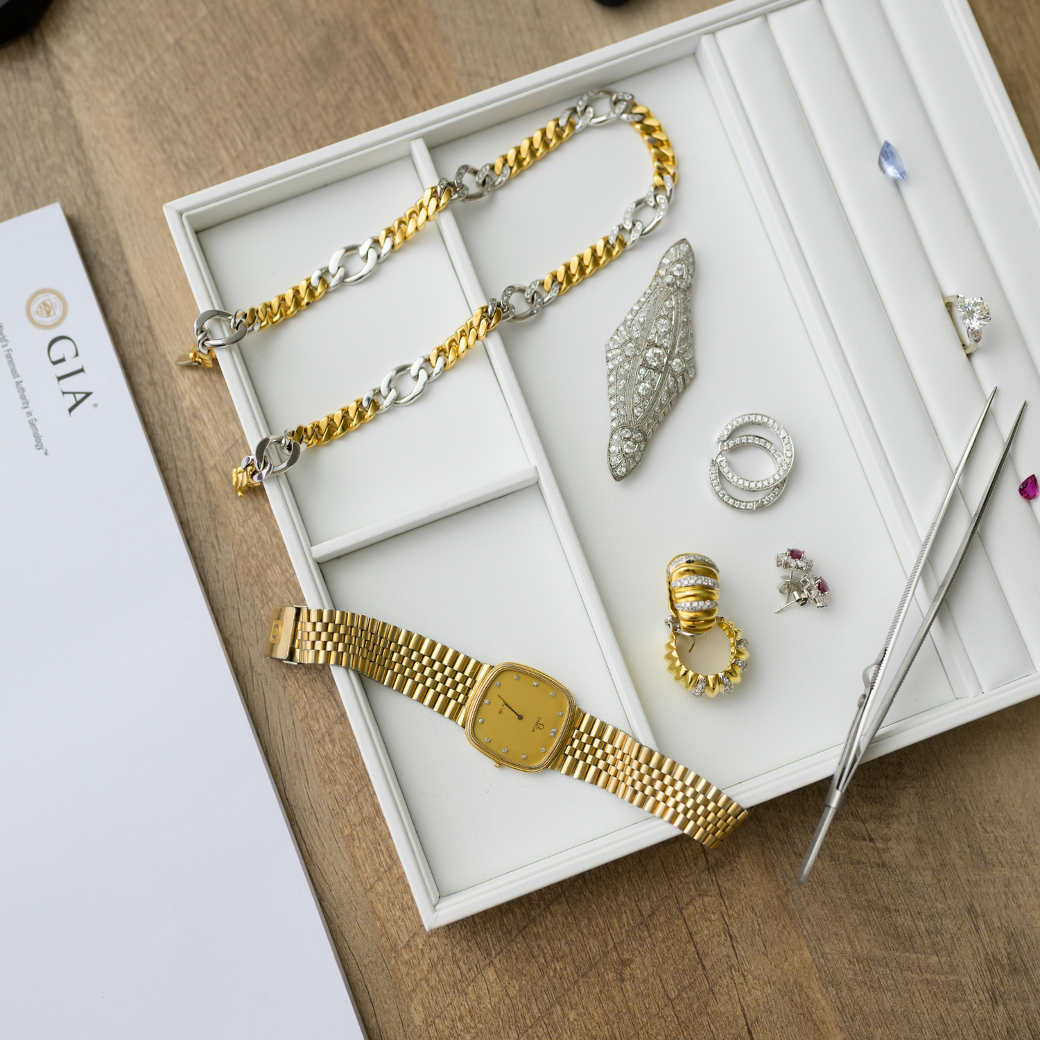 Luxury jewelry and watch collection displayed in a premium organizer, featuring gold and silver pieces, diamonds, and gemstones. Discover fine craftsmanship at Devine Jeweler.