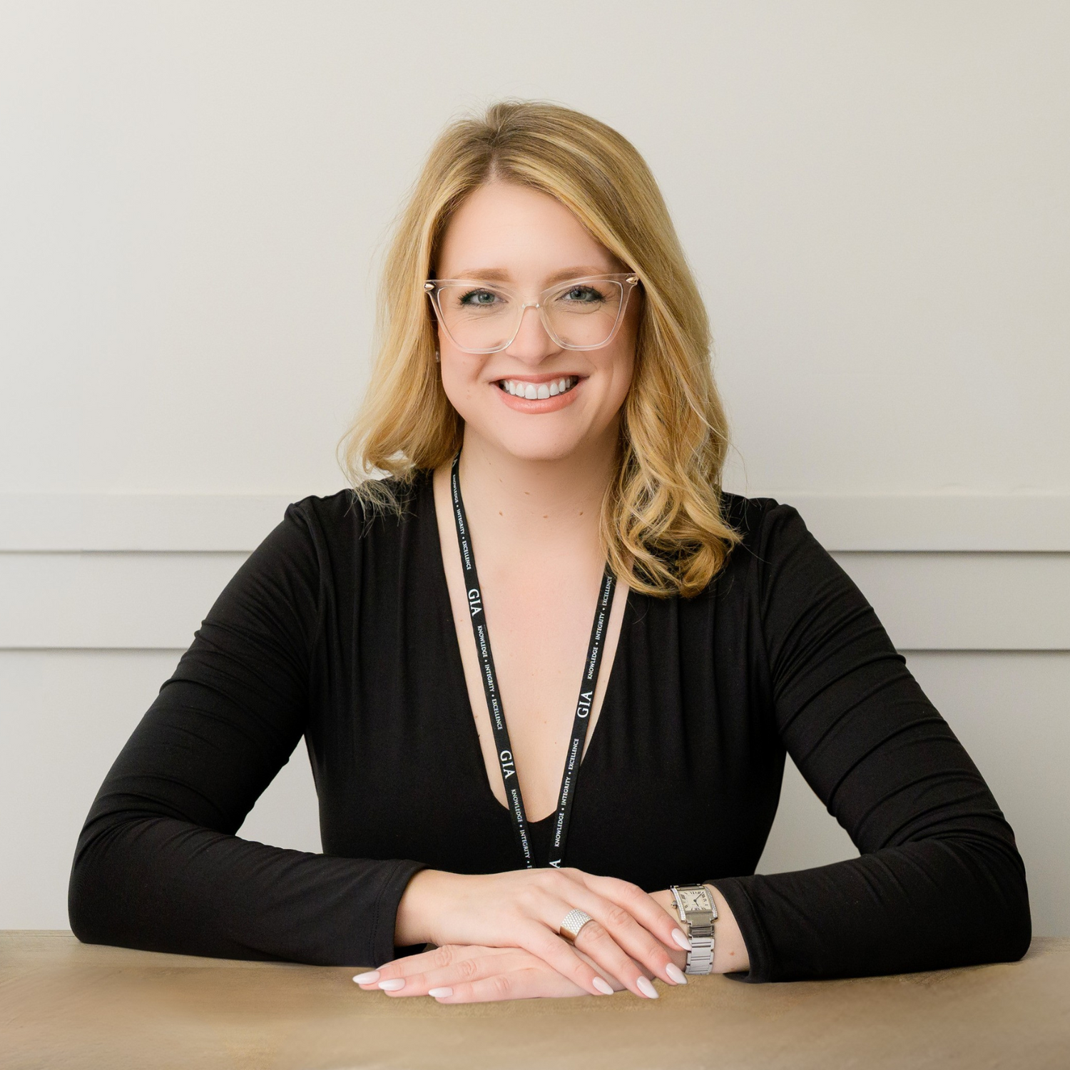 Smiling professional jeweler wearing a GIA lanyard, ready to assist with custom and luxury jewelry. Explore fine craftsmanship at Devine Jeweler.