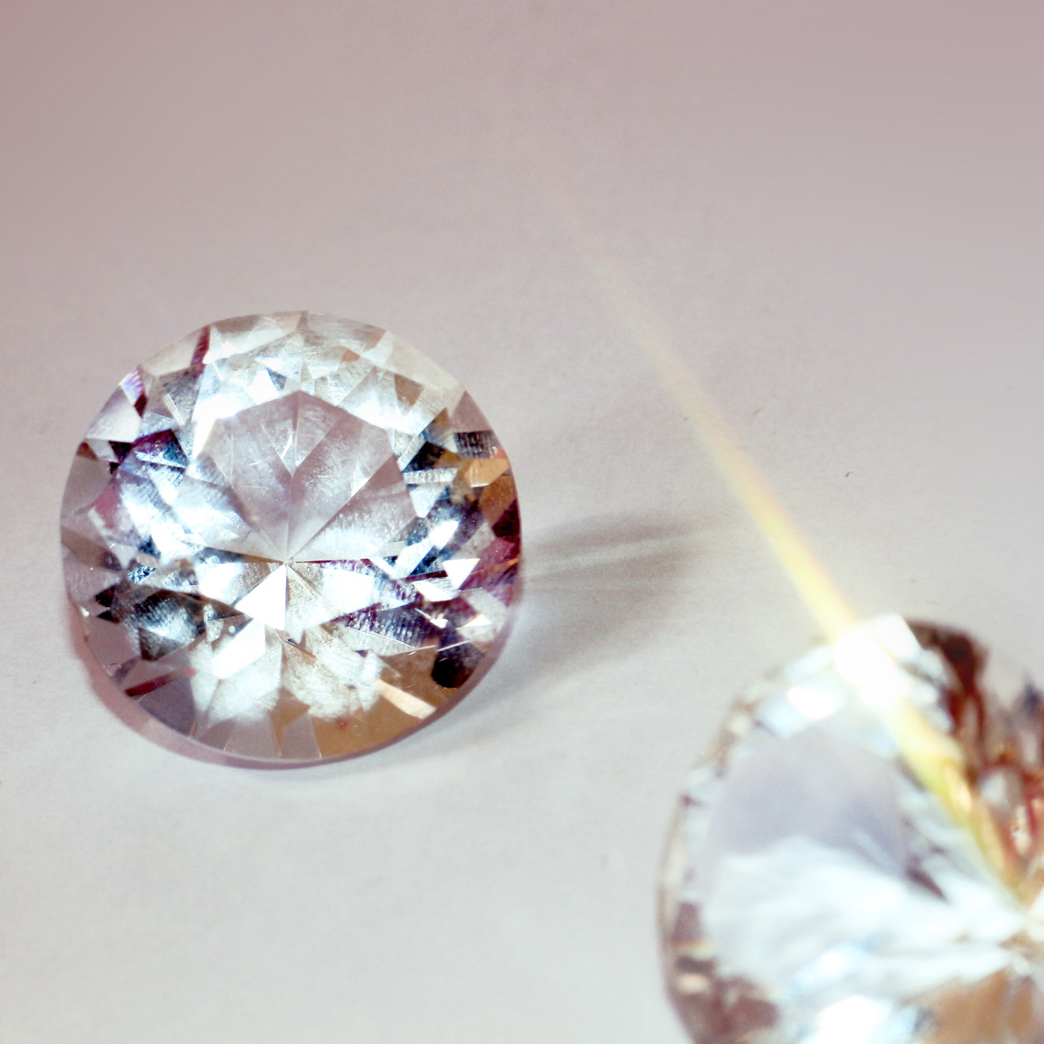 Brilliant round-cut diamonds sparkling under light, showcasing their flawless clarity and elegance. Explore exquisite jewelry at Devine Jeweler.